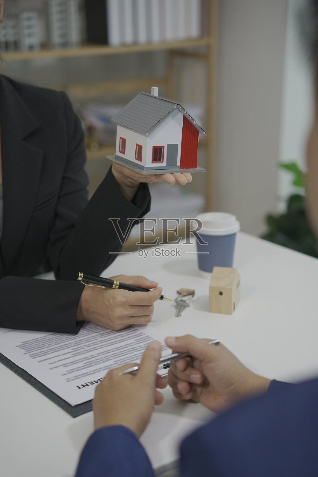 房地产经纪人,销售办事处,房屋保险,房地产房屋员工与客户谈论购买房屋保险,并根据合同协议与客户签订合同。照片摄影图片