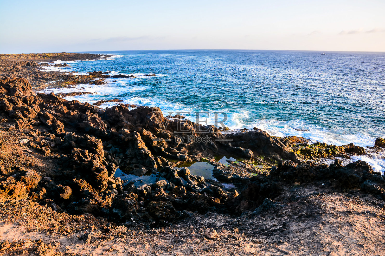 大海风平浪静,岩石参差不齐照片摄影图片
