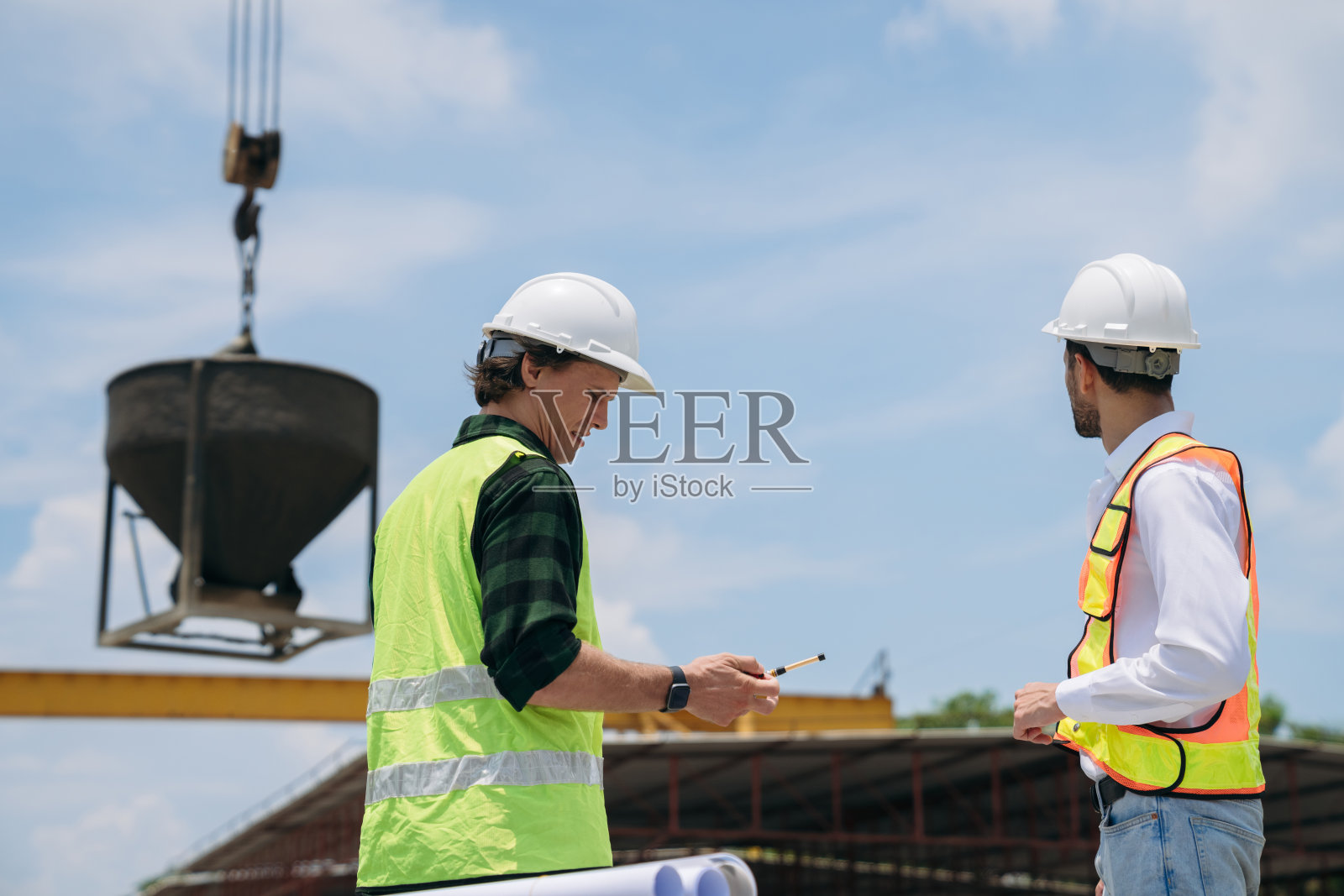 工程师们在建筑工地讨论建筑计划。施工经理和工程师正在合作进行这个项目。照片摄影图片