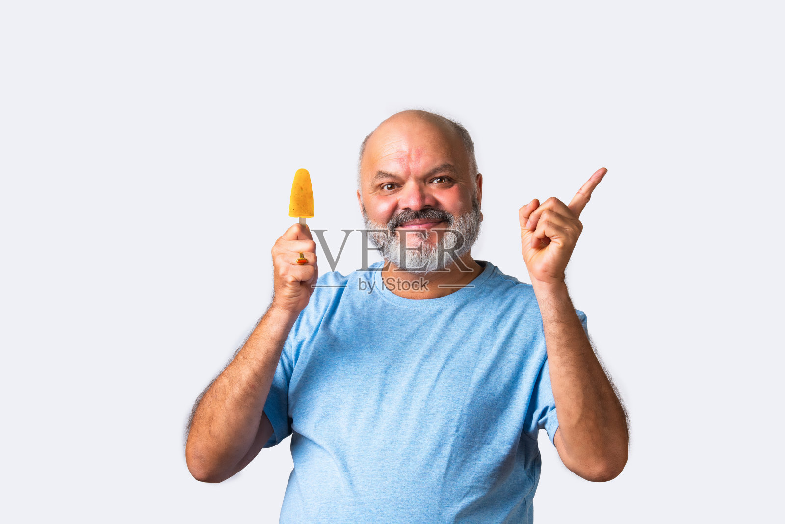 上了年纪的印度亚裔老人吃着甜印度冰淇淋或牛奶冰糖照片摄影图片