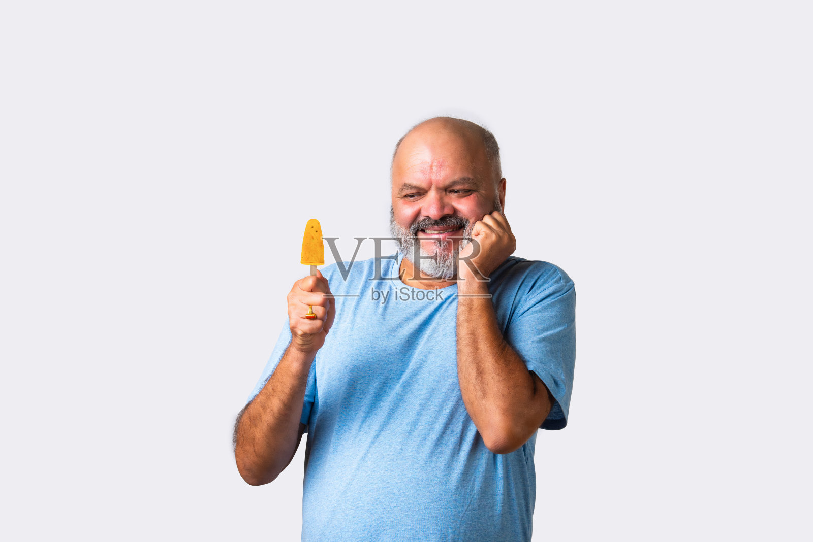 上了年纪的印度亚裔老人吃着甜印度冰淇淋或牛奶冰糖照片摄影图片