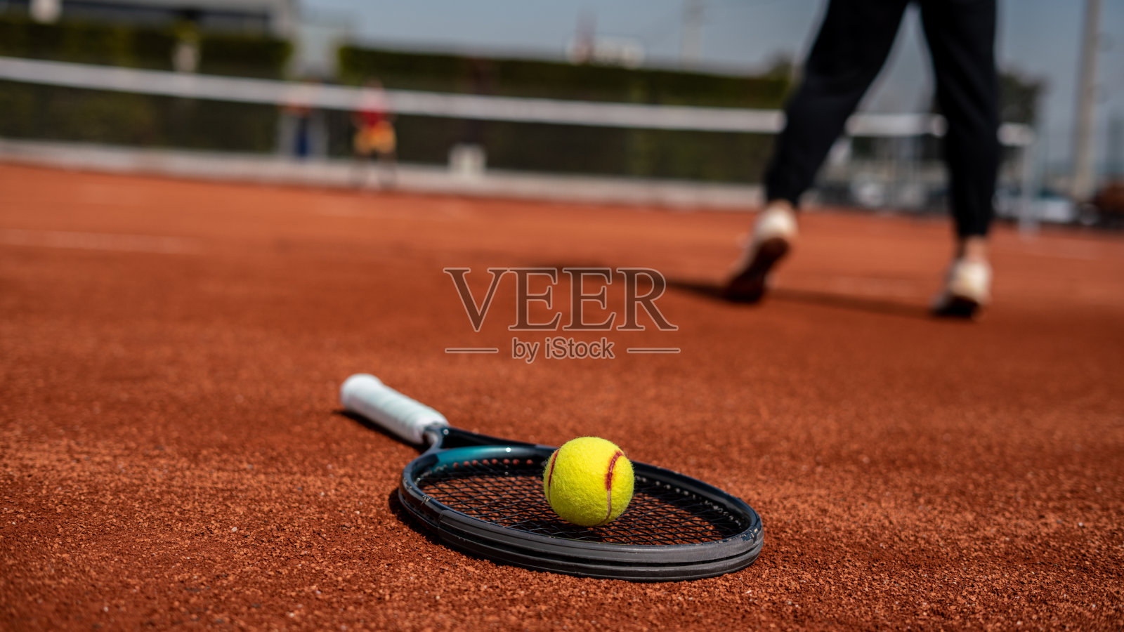 网球拍和球在红土场上,前景集中在前景上,网球运动员是背景水平网球仍然照片摄影图片