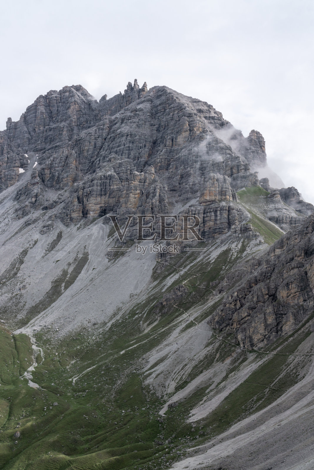 在阿尔卑斯山的岩石上徒步旅行照片摄影图片