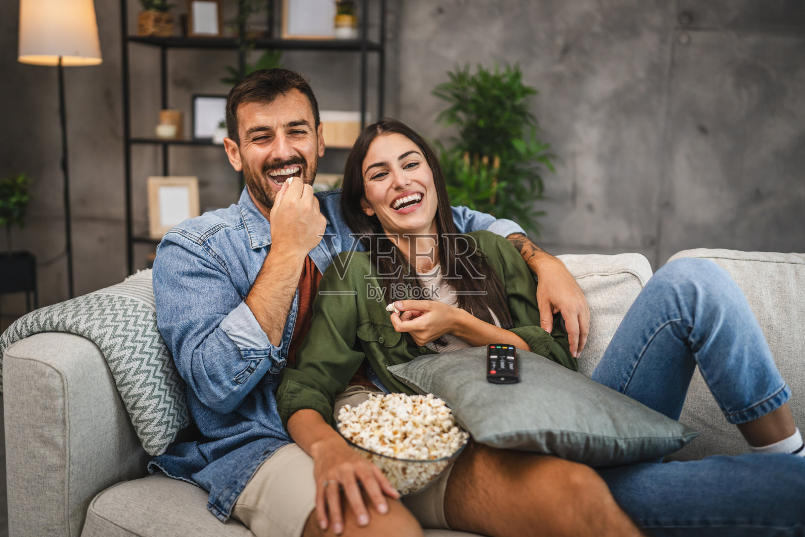 成年夫妇在家里看电影、电视剧、吃爆米花照片摄影图片