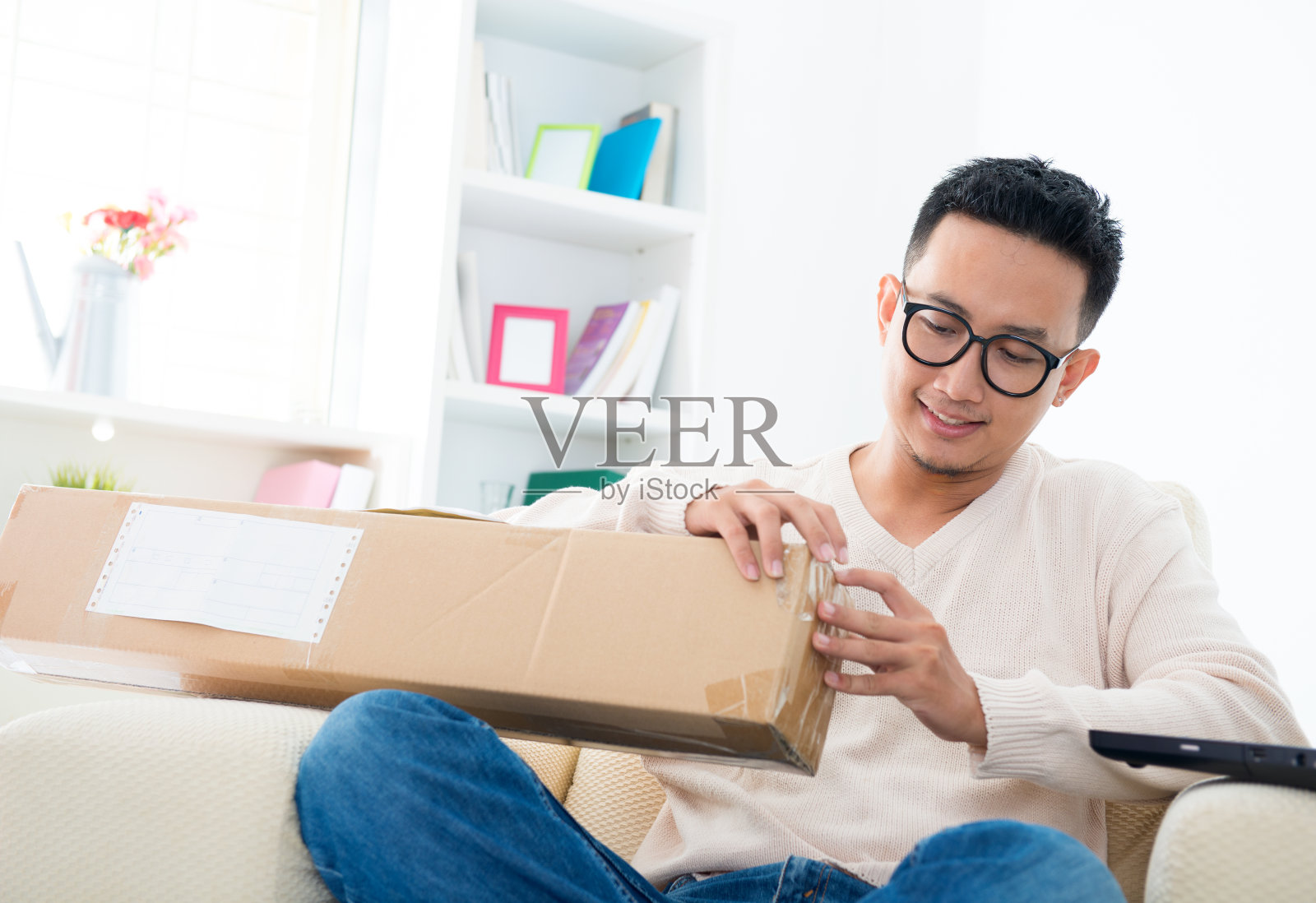 微笑的男人在家里打开盒子照片摄影图片