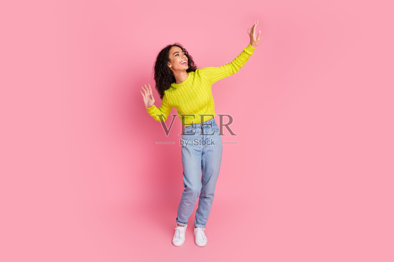 十几岁的女孩的照片肖像波浪的黑发有乐趣跳舞在迪斯科舞厅看空空间孤立的粉红色背景照片摄影图片