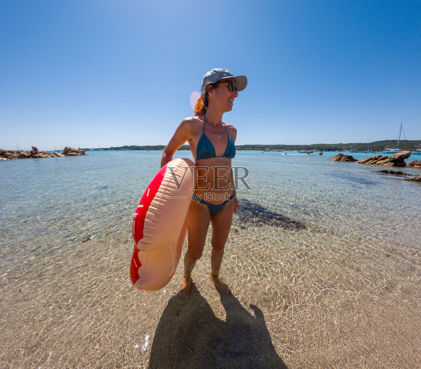 带着充气戒指享受阳光海滩的女人照片摄影图片