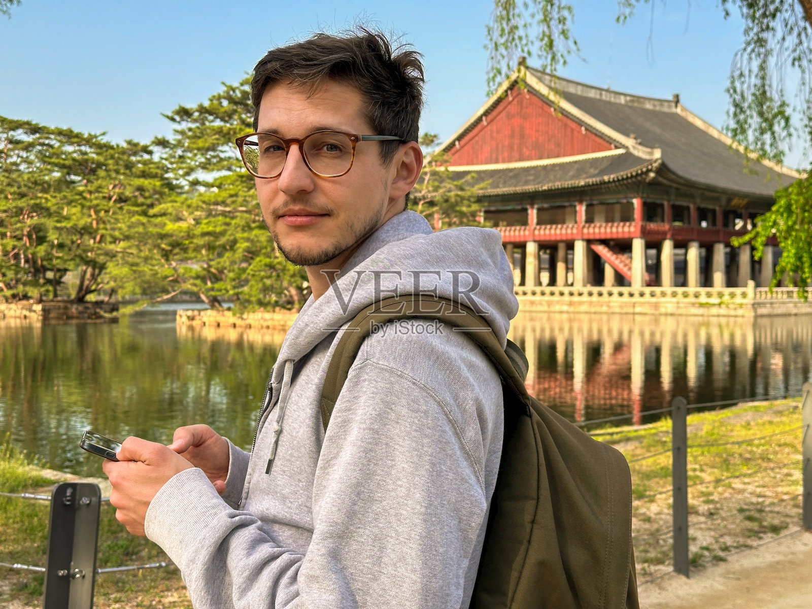 戴眼镜的游客站在水上的韩国宫前照片摄影图片