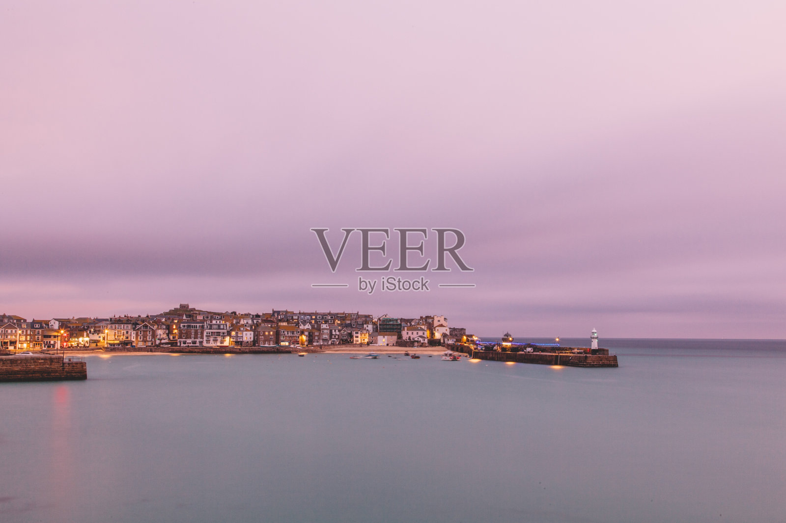 日落时分,大海映衬天空,照亮城市照片摄影图片