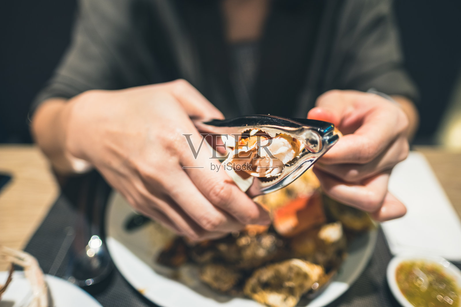 用钳子抓海鲜的手特写照片摄影图片