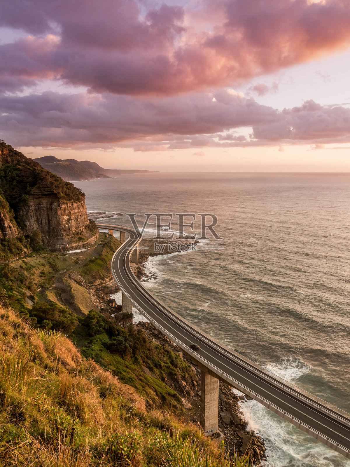 在多云的天空下,海上蜿蜒道路的高角度视图照片摄影图片