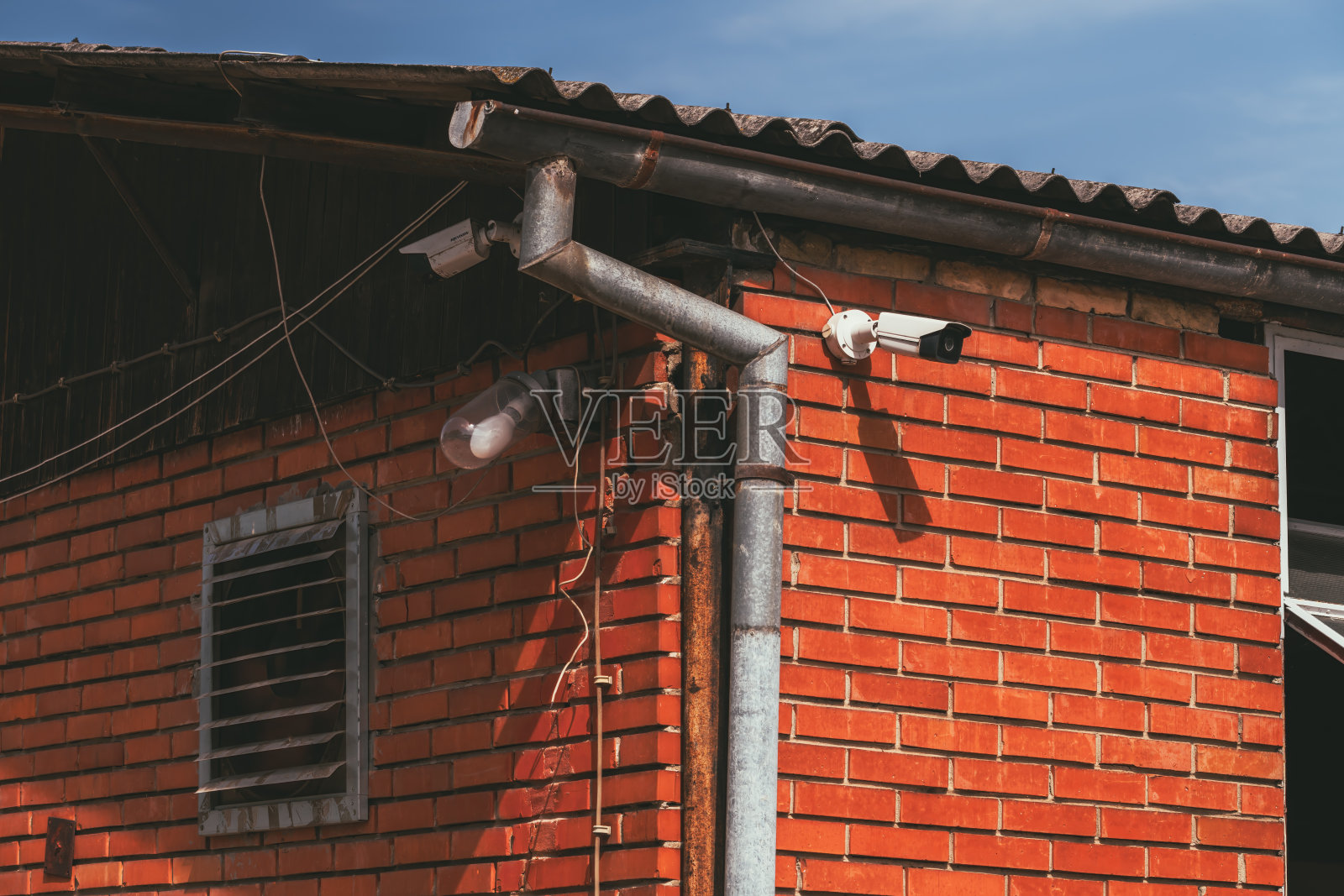 有电风扇、户外灯泡和监控摄像头的旧农场建筑照片摄影图片