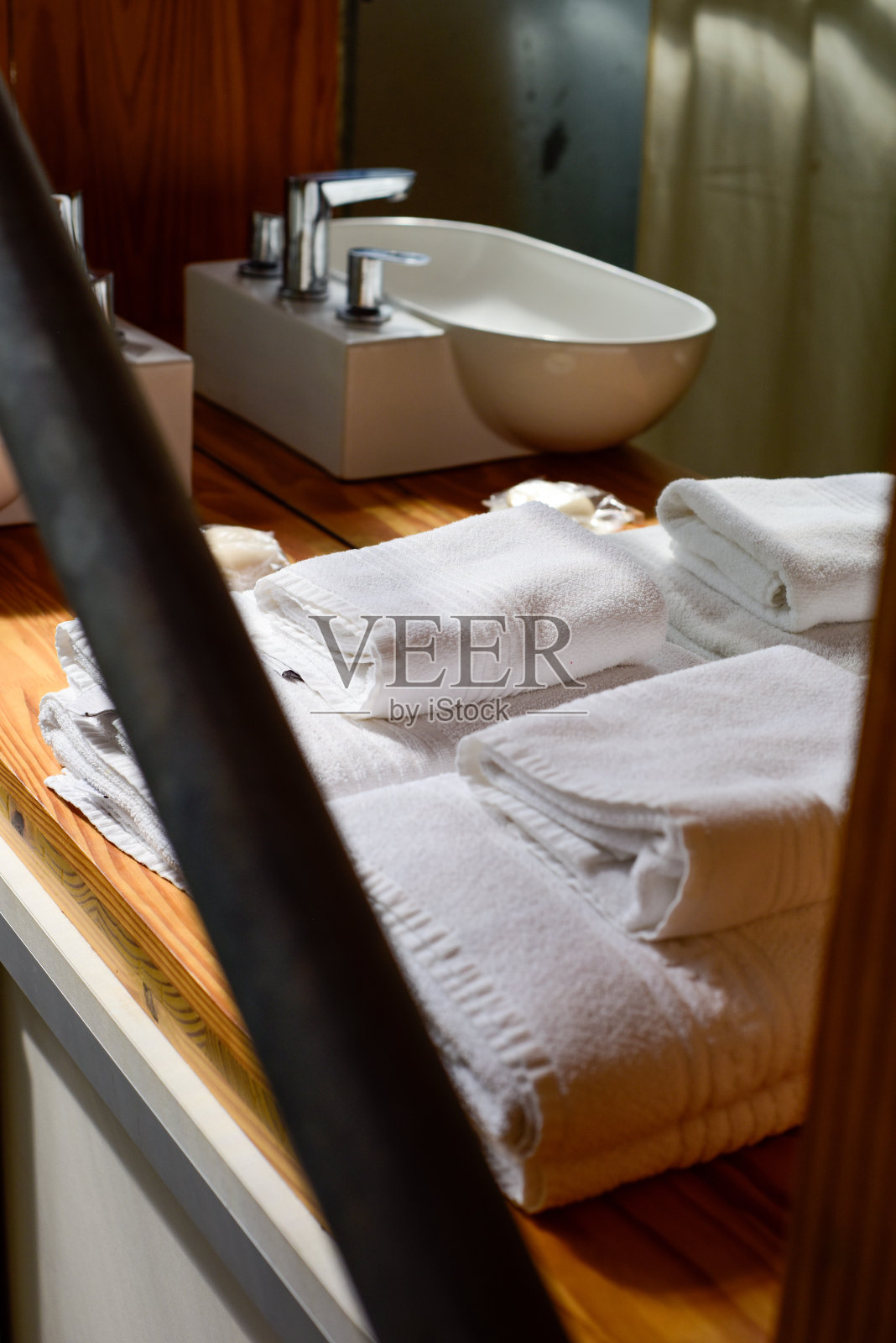 浴室台面配有白色水槽和毛巾,位于现代舒适的阁楼内。照片摄影图片