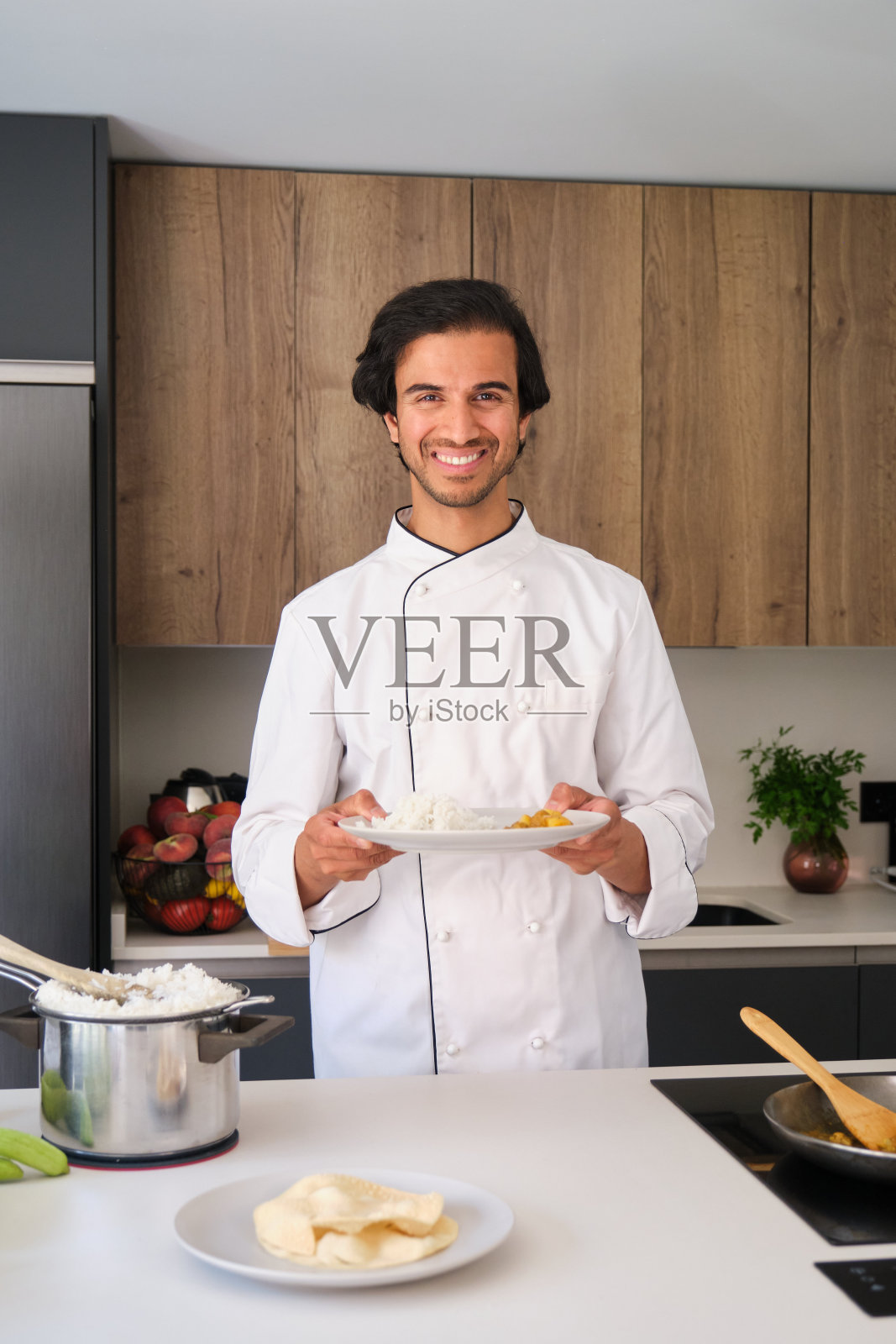 印度厨师在厨房里微笑着拿着一盘食物照片摄影图片