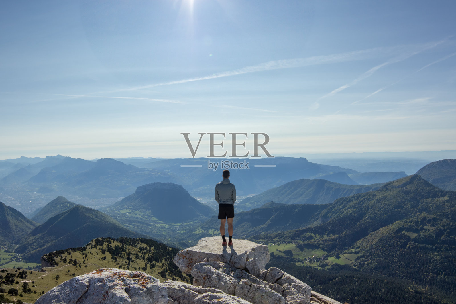 背对天空站在悬崖上的人的后视图照片摄影图片