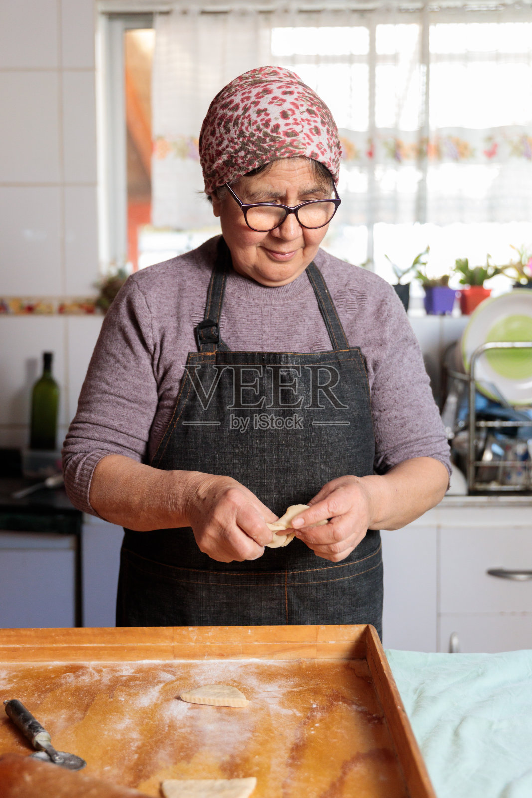 传统的拉丁老年妇女在她简朴的家庭厨房里做饭和准备自制饭菜照片摄影图片