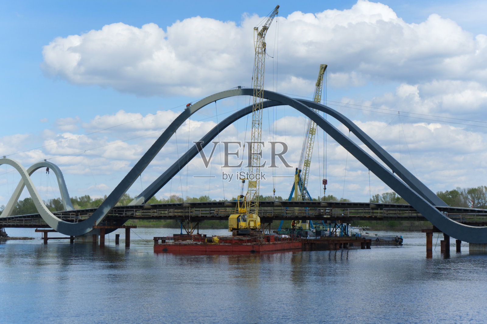 一座正在建造的拱桥横跨河流。照片摄影图片