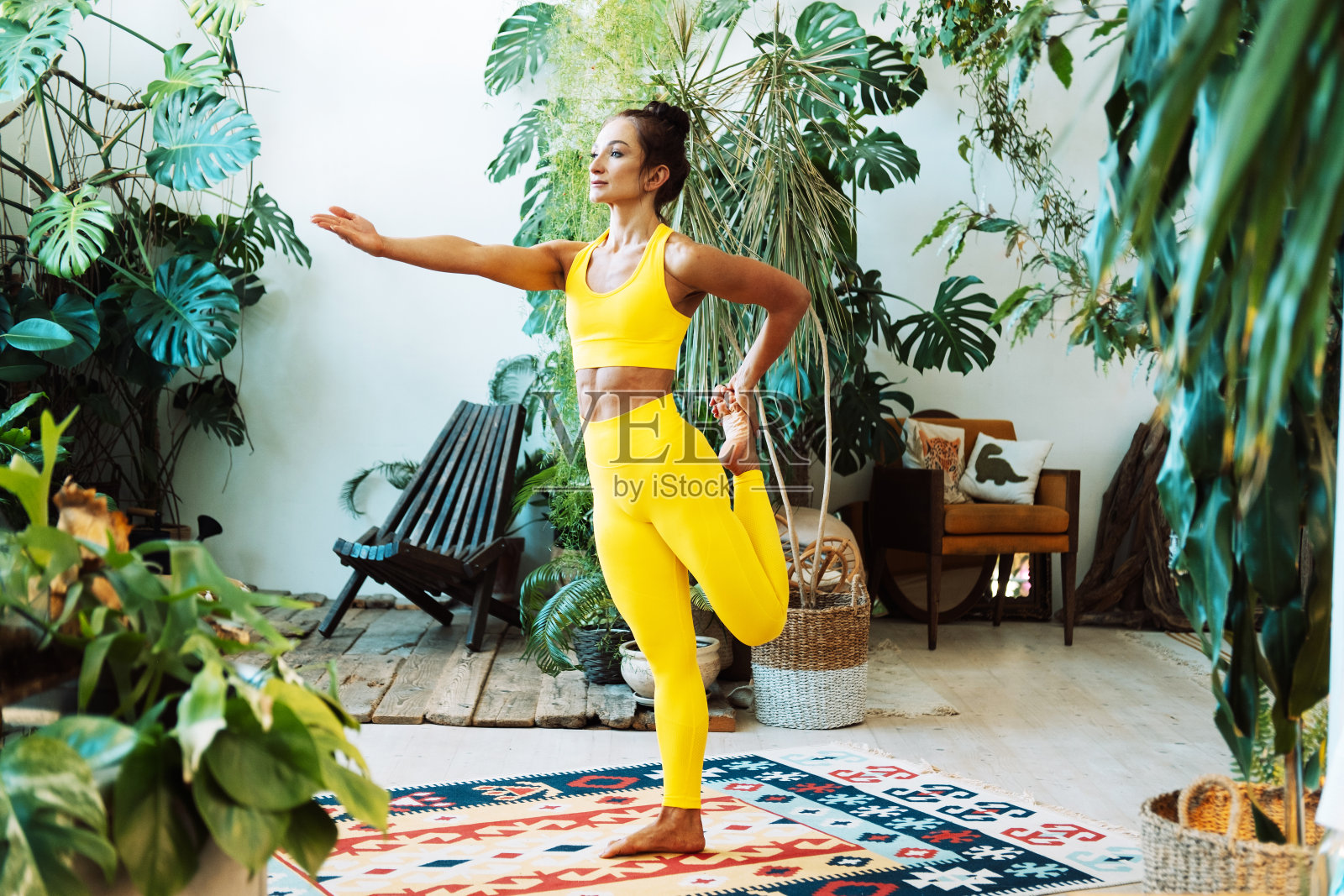 一名妇女在城市丛林中练习瑜伽。女性在家做瑜伽和普拉提。照片摄影图片