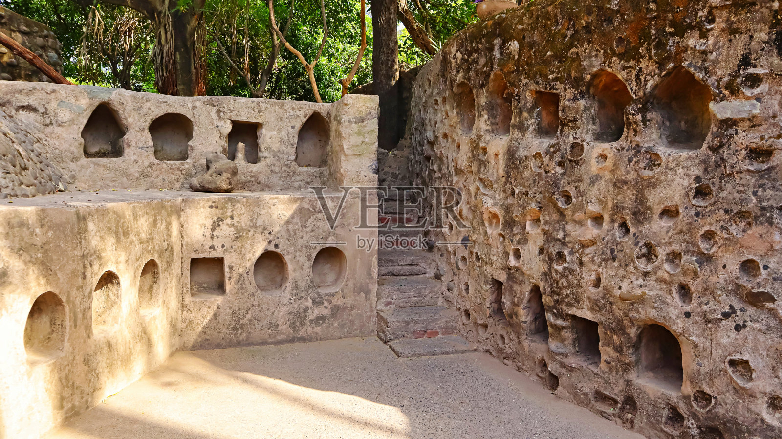 印度昌迪加尔,岩石花园内的石雕和一条小通道。照片摄影图片