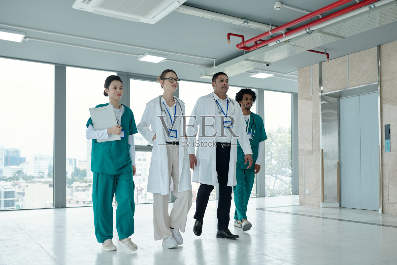 医生们沿着诊所的走廊走照片摄影图片