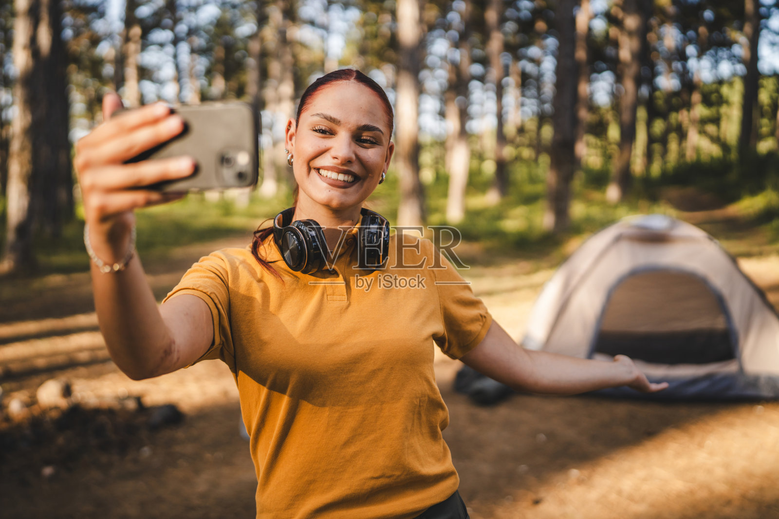 戴着耳机的年轻女子的自画像和帐篷照片摄影图片