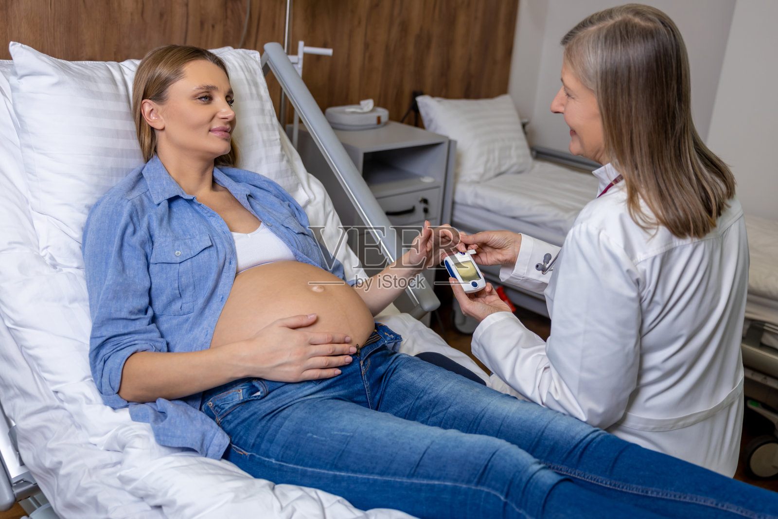 医生用血糖仪测量孕妇的血糖水平照片摄影图片