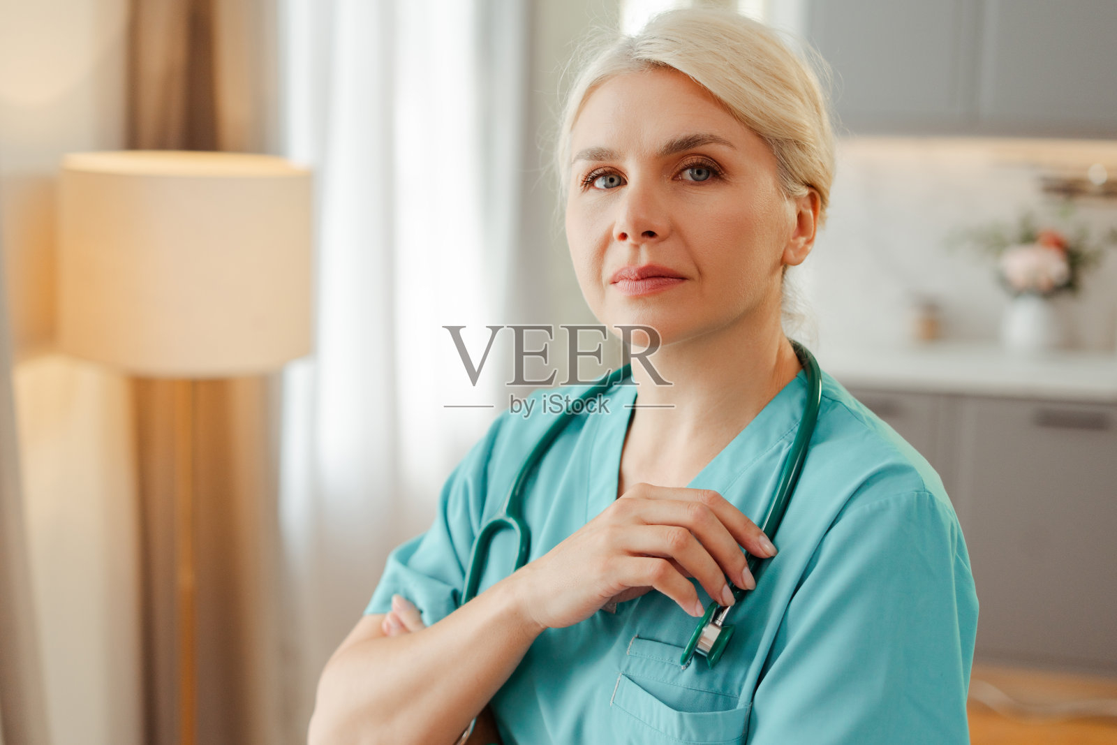 自信的女医生穿着手术服,双臂交叉站在医院里看着镜头照片摄影图片