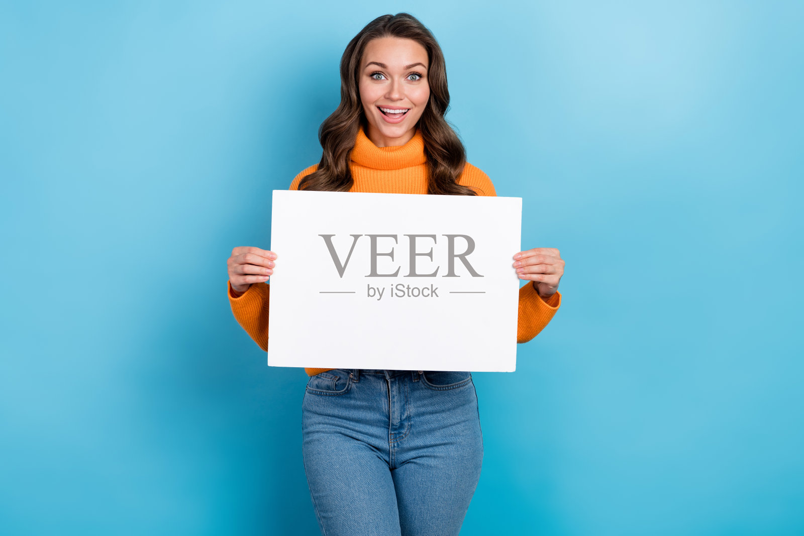 照片中兴奋有趣的女士穿着橙色的套头衫升起白色的标语,空白的空间孤立的蓝色背景照片摄影图片