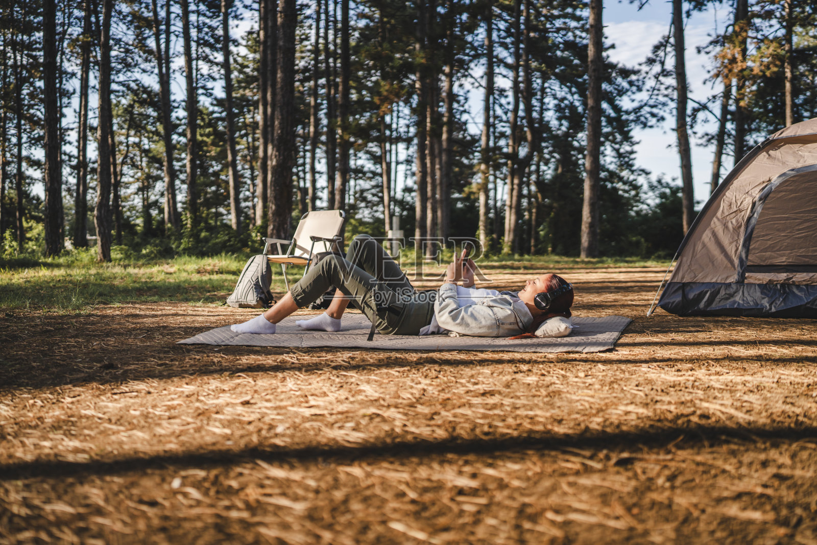 戴着耳机的年轻女子用手机听音乐照片摄影图片