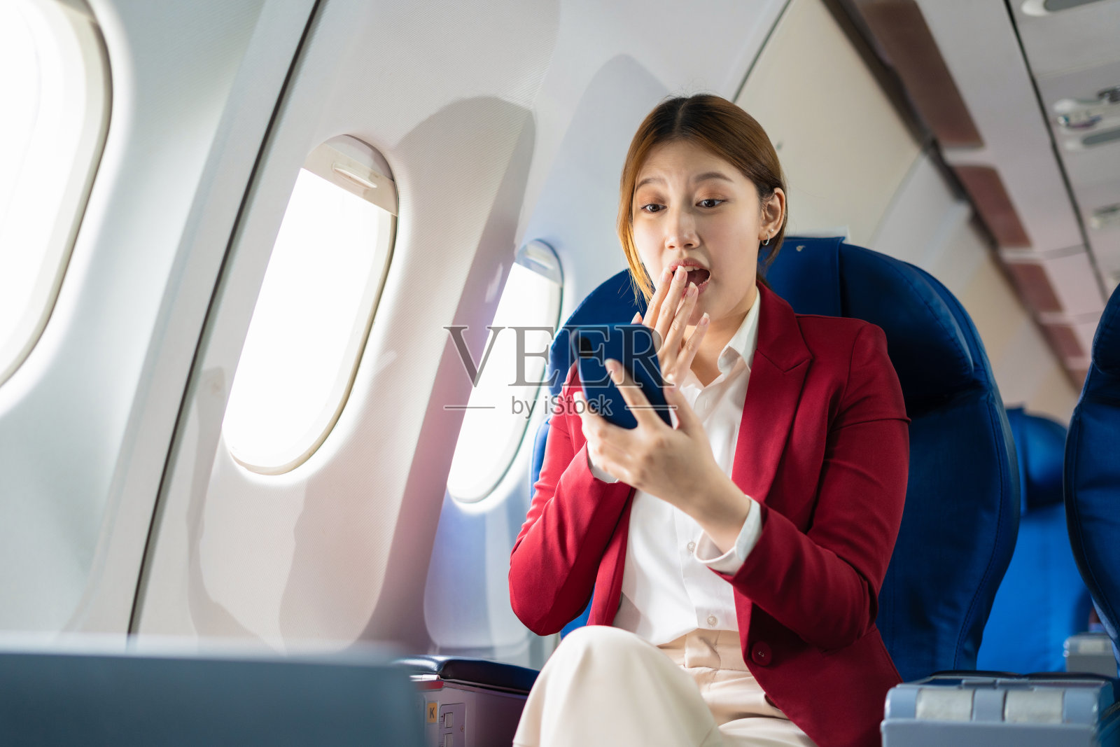 飞机,旅行和商人的肖像在笔记本电脑和智能手机上工作,而坐在飞机上。照片摄影图片