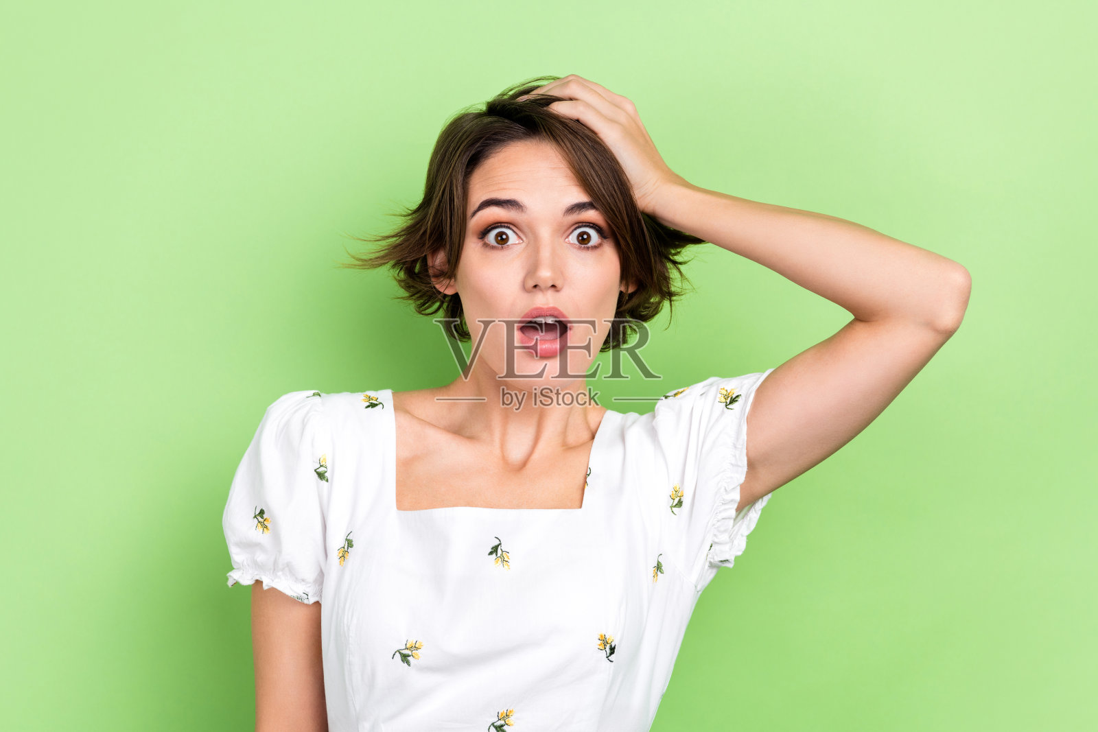 目瞪口呆的女士张开嘴忘记了重要的事情摸头白痴穿短白衬衫孤立的绿色背景照片摄影图片