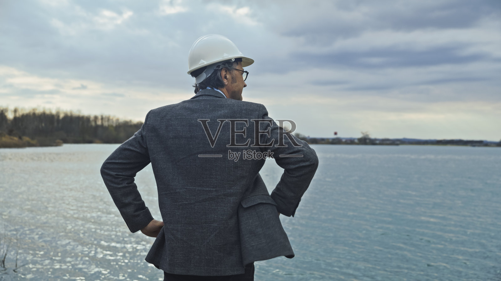 戴头盔的工程师看湖水库的后视图照片摄影图片