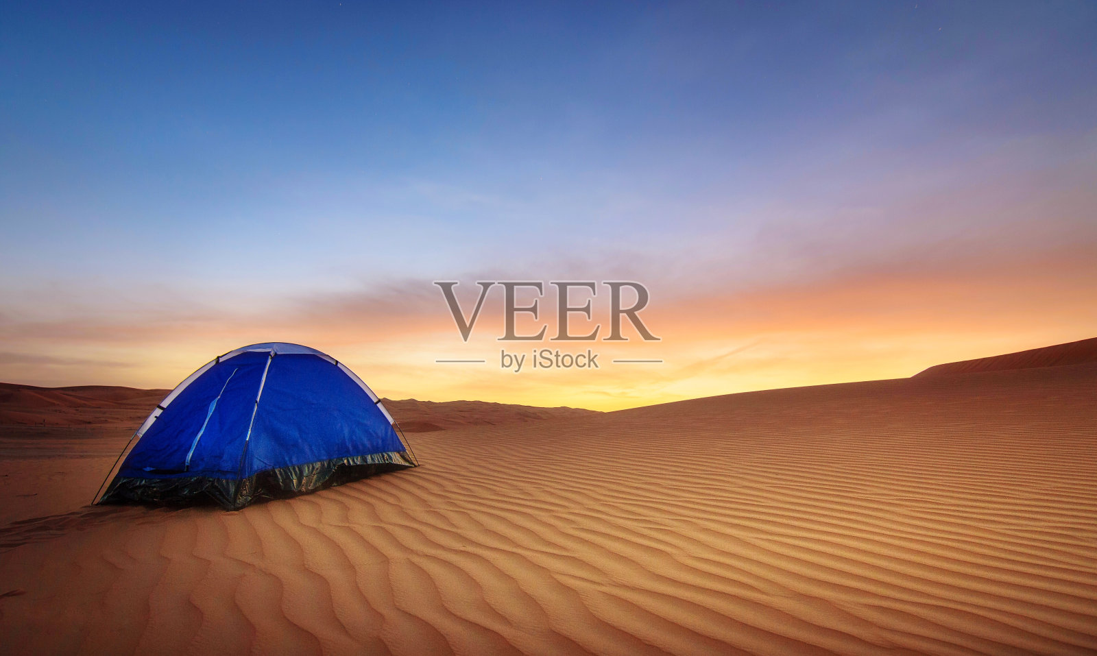 日落时分沙漠中的蓝色帐篷照片摄影图片