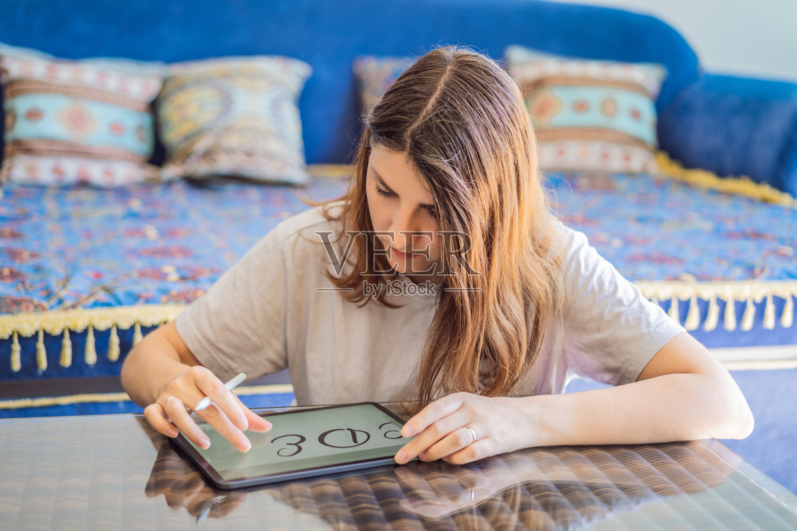 书法家年轻女子在数字平板上写短语。铭刻装饰性的装饰字母。书法、平面设计、刻字、手写、创作照片摄影图片