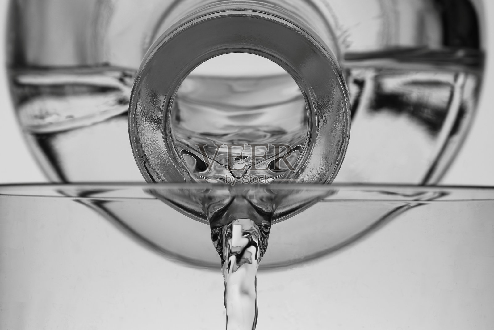 水从瓶子里倒出来的特写,背景是白色照片摄影图片