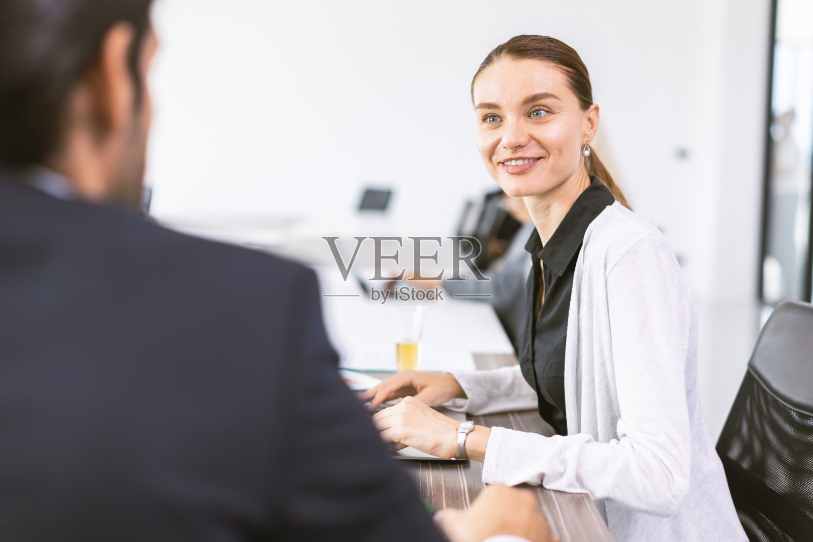 商务女性在办公室与老板交谈,营销秘书在桌子上与经理愉快地汇报信息以作决定照片摄影图片