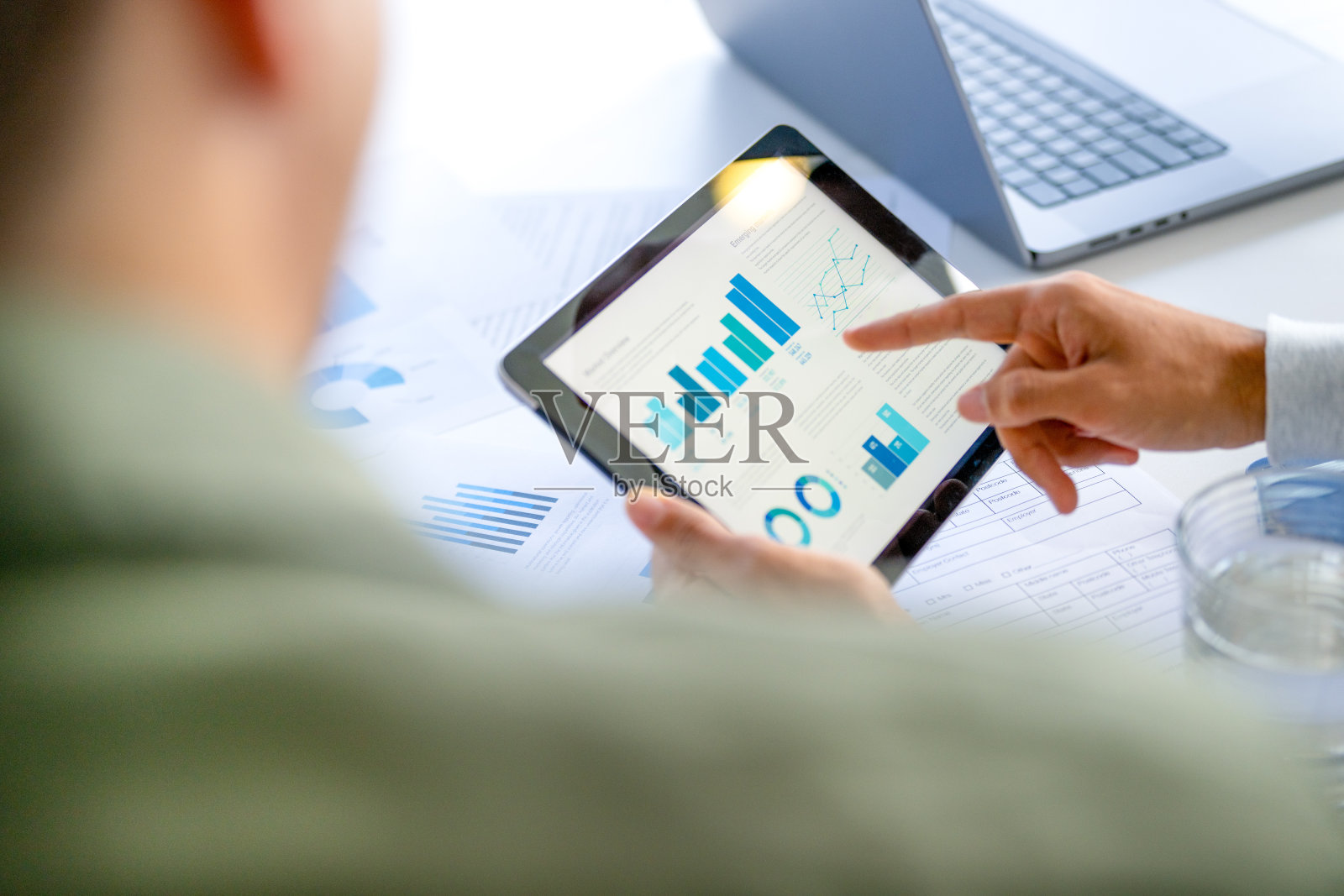 两个商人开会,在平板电脑和笔记本电脑上查看财务数据、图表和图表。照片摄影图片