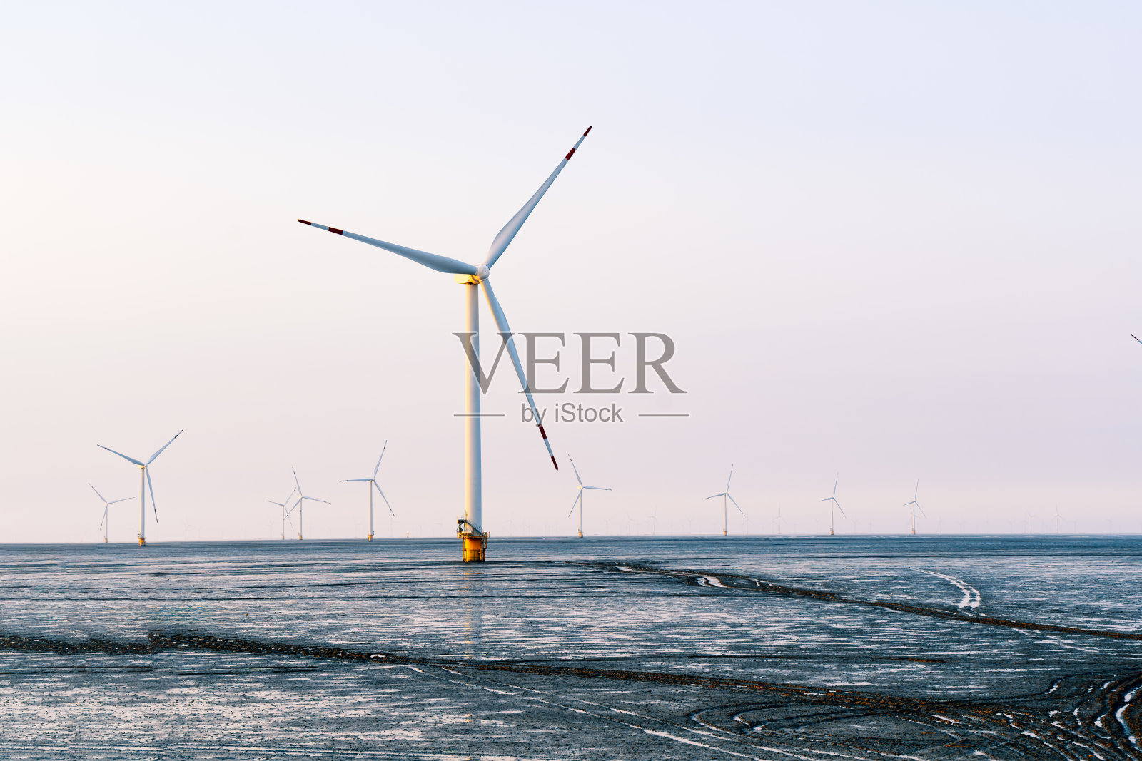 风力发电机在日落时分清洁发电照片摄影图片