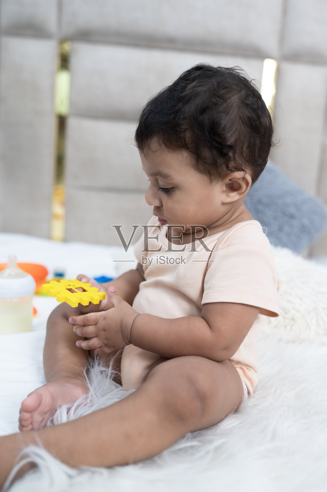 可爱的婴儿坐在床上的特写照片摄影图片