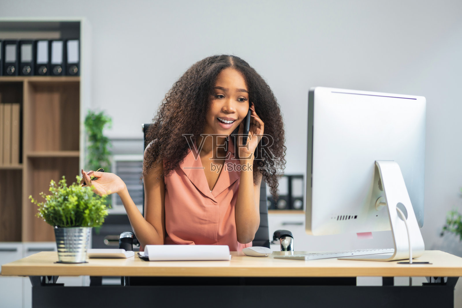 女商人讲手机,用笔记本电脑工作,网上做生意。照片摄影图片