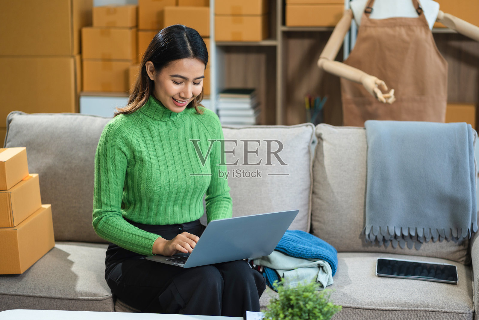 成功的女性网上卖家。小型企业企业家或亚洲女性自由职业者与网上销售在家里。照片摄影图片