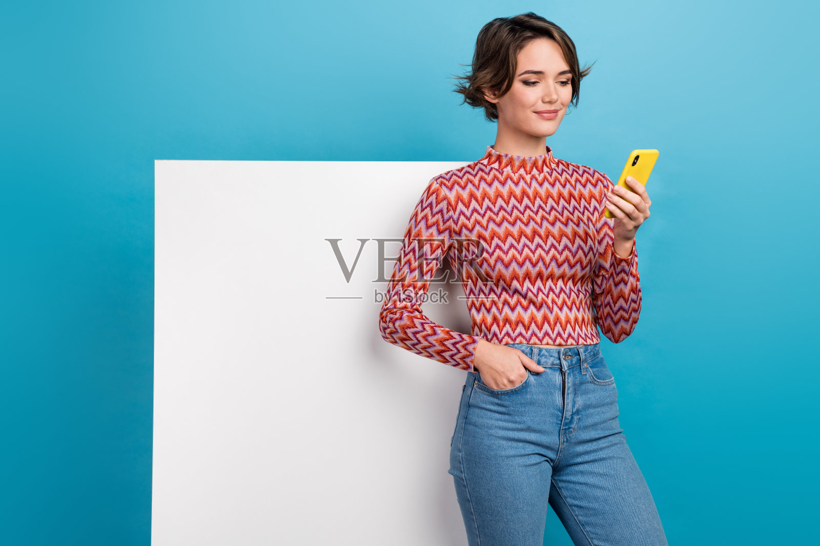 照片的漂亮积极的女人穿着粉红色的衬衫发短信现代设备标牌空白空间孤立的蓝色背景照片摄影图片