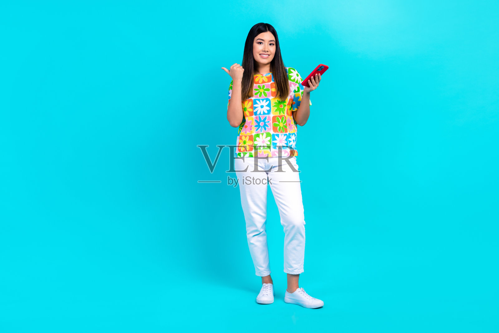 中国年轻博主女孩手持手机点指空白空间网站界面孤立在青色背景上照片摄影图片