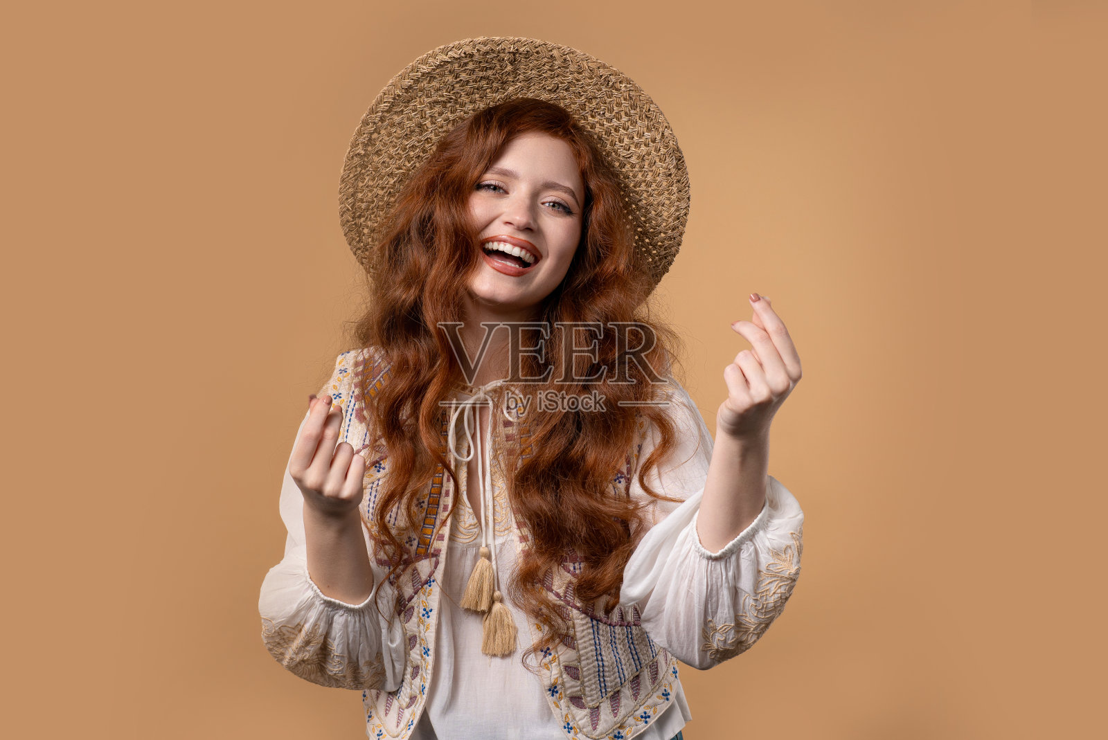 米色画室背景上,年轻女子拿着钱的手势。聪明的女士微笑着照片摄影图片