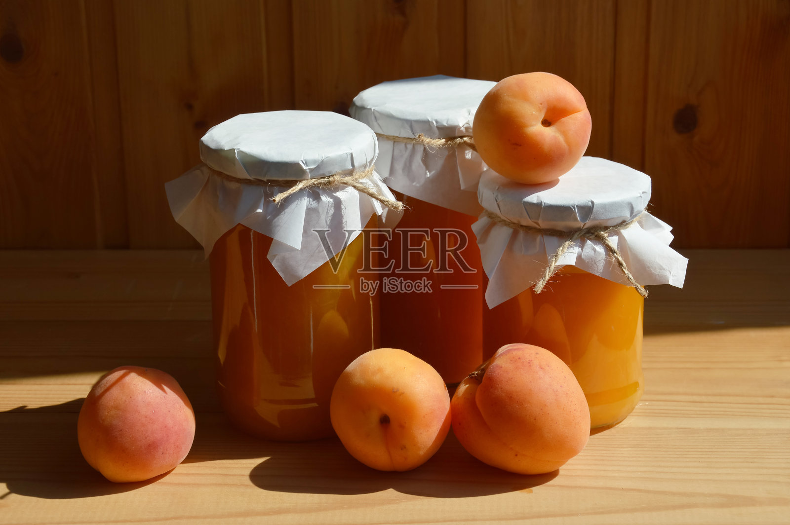 装在玻璃罐里的杏果酱,甜甜的蜜饯,自制的水果糖果。成熟多汁的水果。设计背景。照片摄影图片