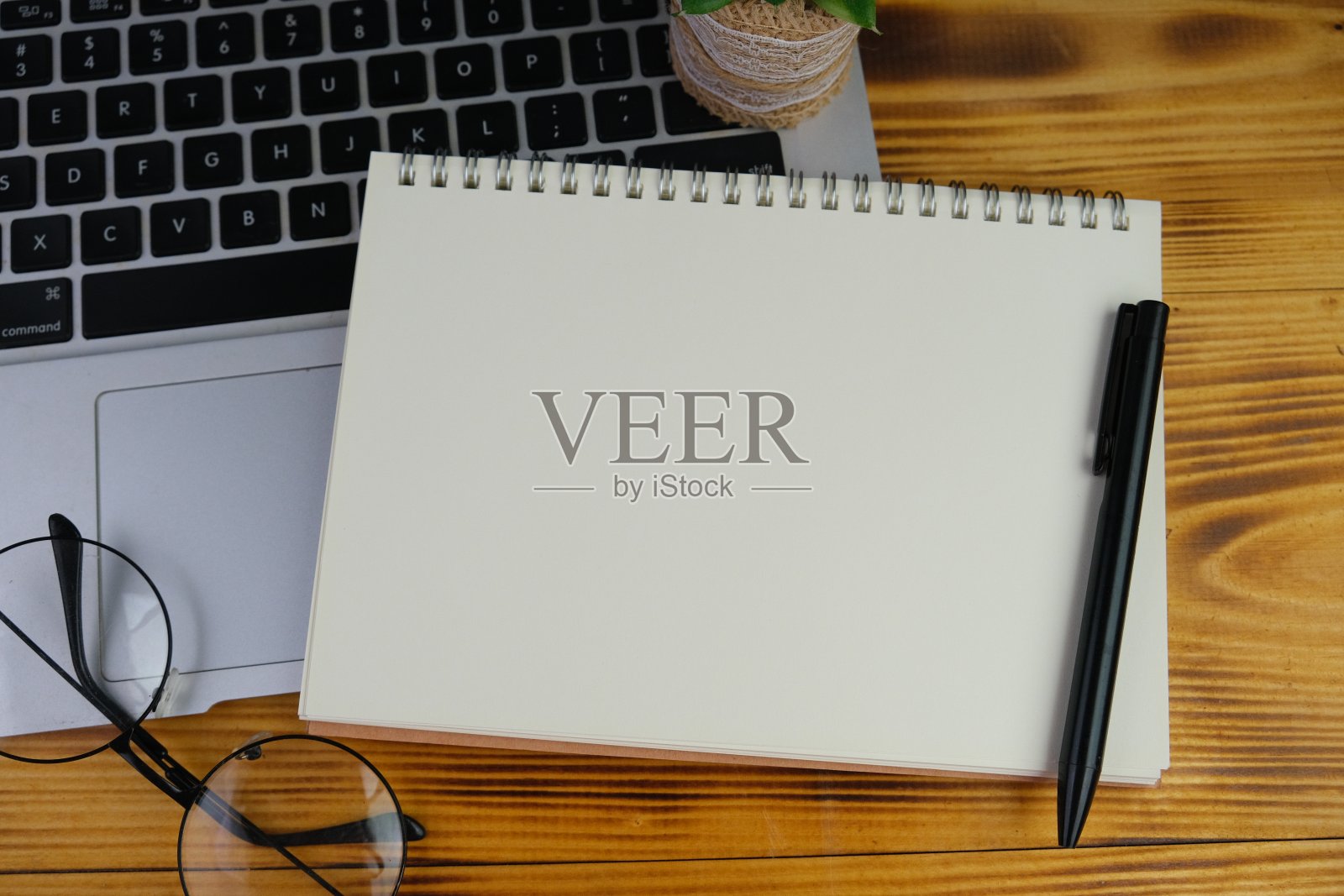 一张木桌上放着笔记本电脑和笔记本电脑的工作场所。教育、商务及办公理念。照片摄影图片