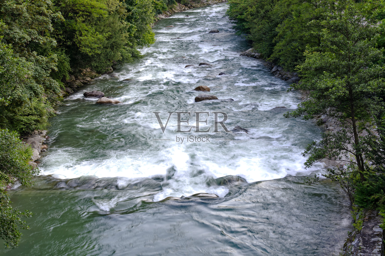 在一个阳光明媚的日子里,意大利梅拉诺镇的帕斯帕西里奥河(Passer Passirio river)上的田园风光。照片摄影图片