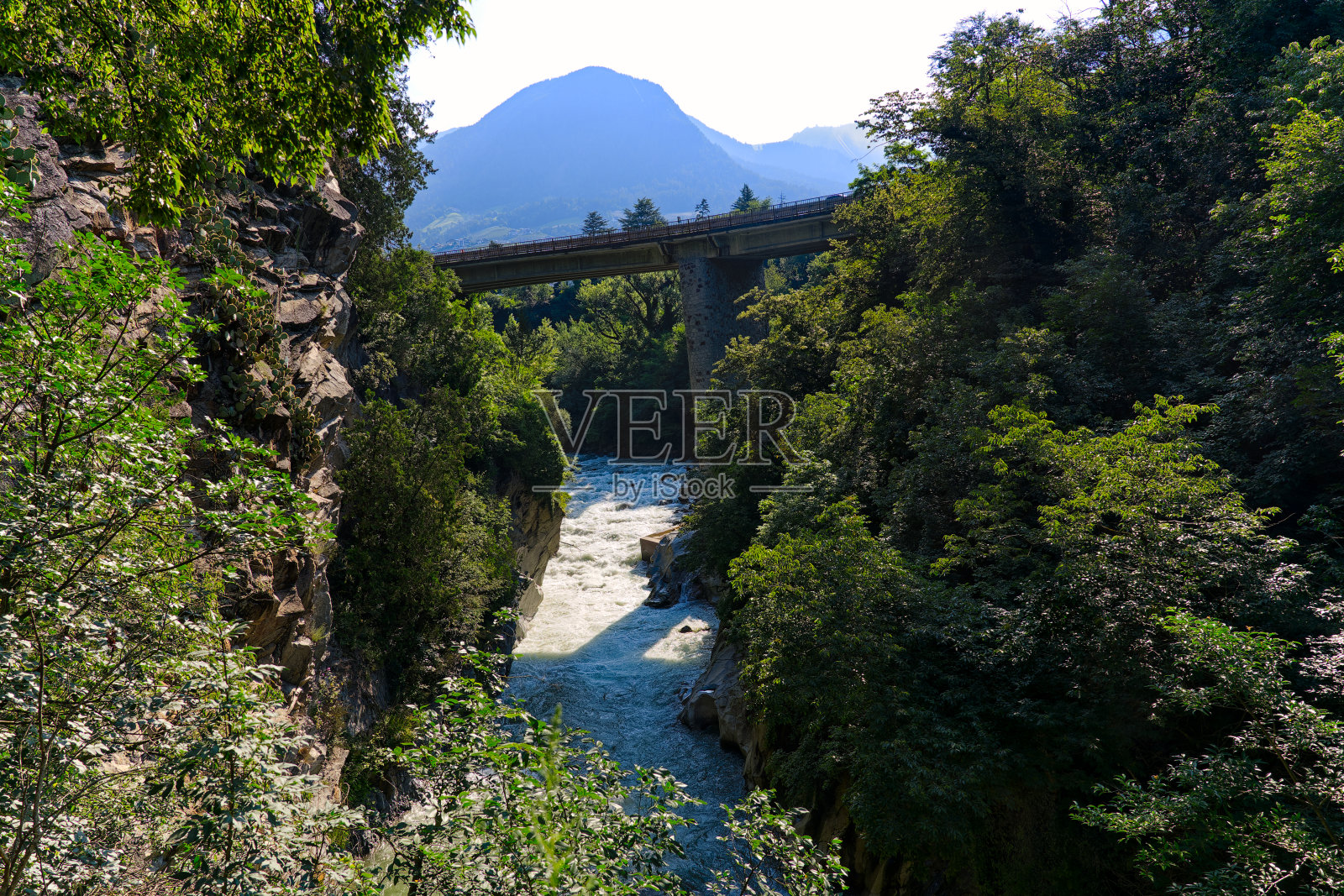 在一个阳光明媚的日子里,意大利梅拉诺镇的帕斯帕西里奥河(Passer Passirio river)上的田园风光。照片摄影图片