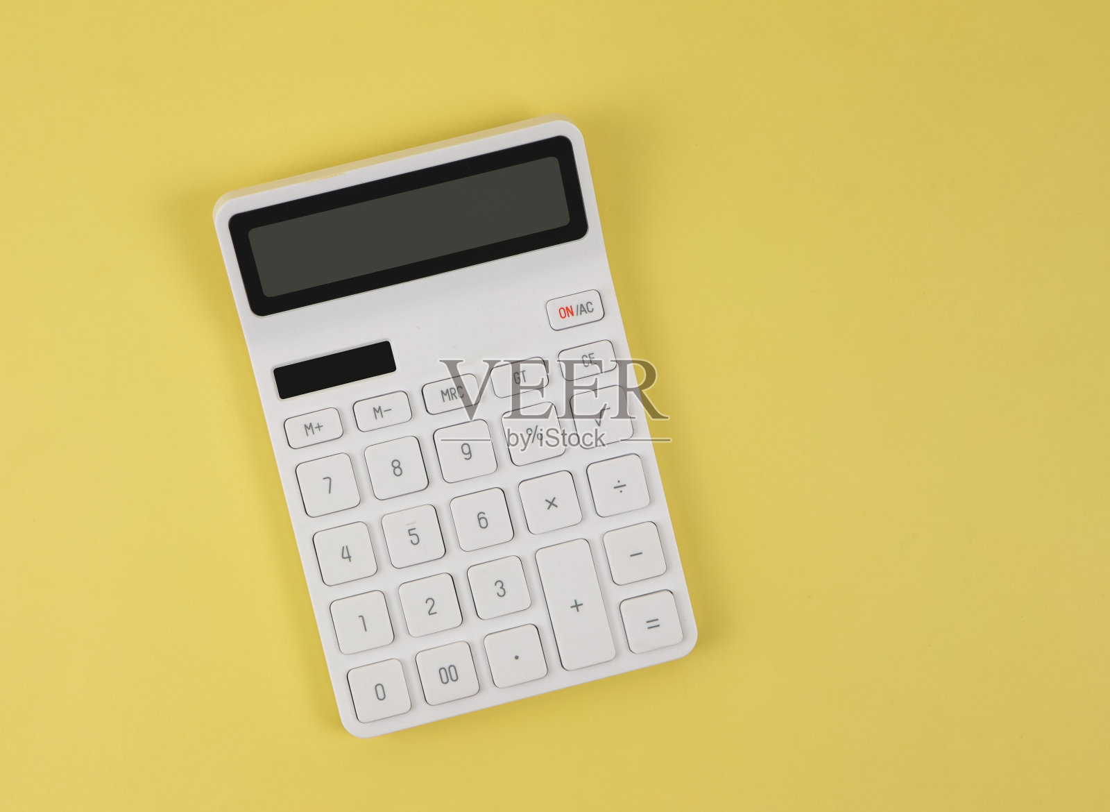 白色计算器在黄色背景上的平面布局与复制空间。照片摄影图片
