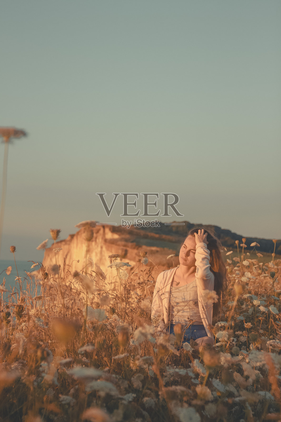 年轻女子在海岸线上的草地上度假照片摄影图片